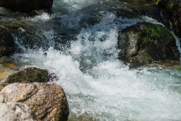 Fast water stream. Mountains river with rocky coasts