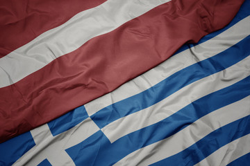 waving colorful flag of greece and national flag of latvia.