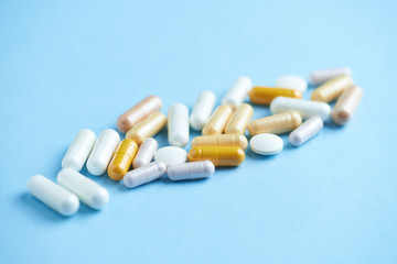 Vitamins and supplements on bright paper background. Concept for a healthy dietary supplementation. Close up. Copy space. 