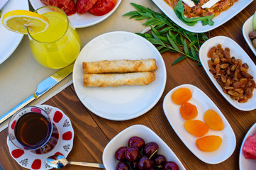 Top view of a healthy breakfast table composed of pastry, golden raisins, orange juice, dried apricots and cherry