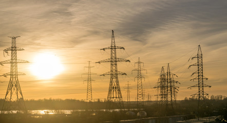 electricity pylons with cables going into the distance at dawn or dusk.  