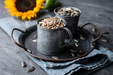 Healthy snack, a heap of whole and peeled sunflower seeds in jars
