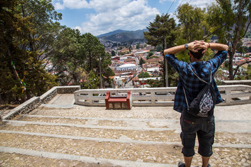 San Cristobal de las Casas, Chiapas / Mexico »; April 2018: A tourist watching The views of the city from the church of Cerrillo