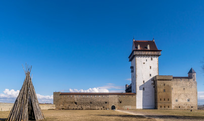 Narva or Hermann castle on a sunny day with a wooden tepee made from wood.  © johnpaul