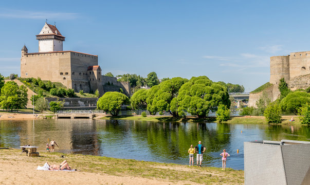 Narva castle or Hermann castle on a sunny day with sunbathers enjoying the sunshine. 