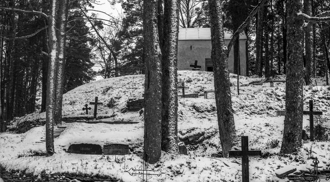 black and white winter images of a forested graveyard