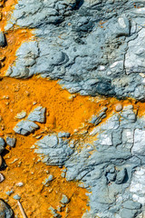 a strange view of blue soil and rocks with an orange water or liquid running through it. 