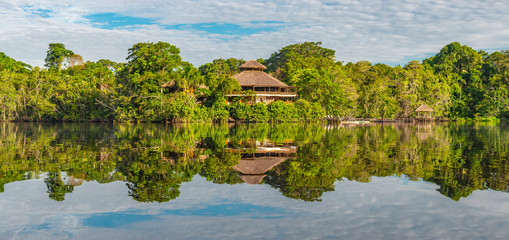 Panoramic rainforest lodge reflection. The tributaries of the Amazon river comprise the countries...