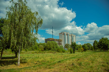 Obraz premium ecology green city picture of suburban building construction scene on park outdoor natural environment foreground with meadow and birch tree