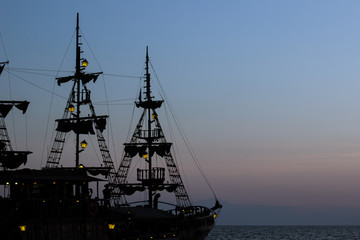 moody cruise vacation picture of vintage medieval ship mast silhouette with lanterns yellow...
