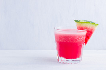 Watermelon drink in glasses with slices of watermelon. Watermelon smoothies on white background. Summer healthy drink for vegetarian. Copy space
