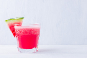 Watermelon drink in glasses with slices of watermelon. Watermelon smoothies on white background. Summer healthy drink for vegetarian. Copy space