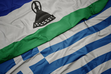 waving colorful flag of greece and national flag of lesotho.