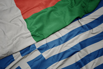 waving colorful flag of greece and national flag of madagascar.