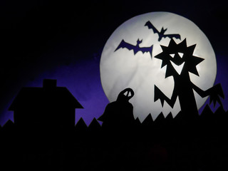 Dark Halloween season background with moon in the background and scary creatures silhouettes. Alien, bats, and funny monster.