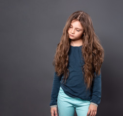 Pupil casual kid girl very want to sleep and standing with closed eyes on  grey studio background