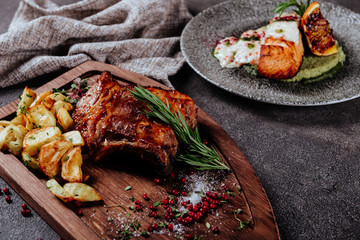 Beef and salmon steaks on the grill with flames top view