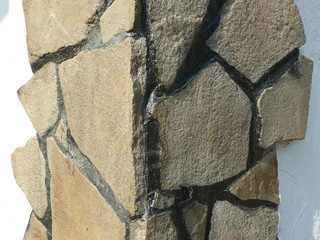 natural stone tiles laid on the corner of the house.