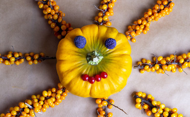 Funny smily sun made of pumpkin and berries. Tasty healthy food with vegetables for children concept.