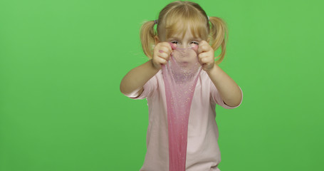 Kid playing with hand made toy slime. Child having fun making pink slime
