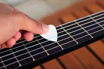 Music Concept: Young and Beautiful woman playing Spanish guitar outdoors in a park.