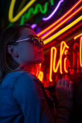 creative portrait of a girl in neon lighting with glasses