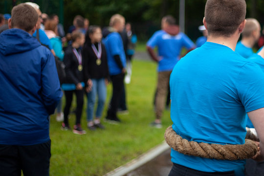 Men Are Holding A Conat. Athletes Strongman. A Huge Rope For Pulling Between Rivals. Sports Competition For Victory.