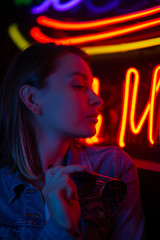 creative portrait of a girl in neon lighting with glasses