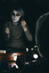 Fototapeta na wymiar girl doing halloween makeup in front of the mirror