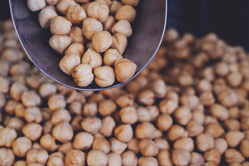 spoon with roasted hazelnuts on hazelnut background. Prepared with the harvest of hazelnuts. Flat lay.