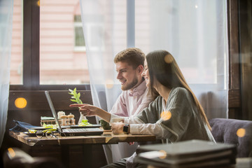 couple guy and girl working in cafe with laptop