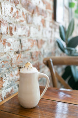 Lavender london fog tea latte with steamed milk and sugar on table in cafe, brick background, copy space