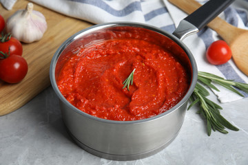 Delicious tomato sauce in pan on marble table
