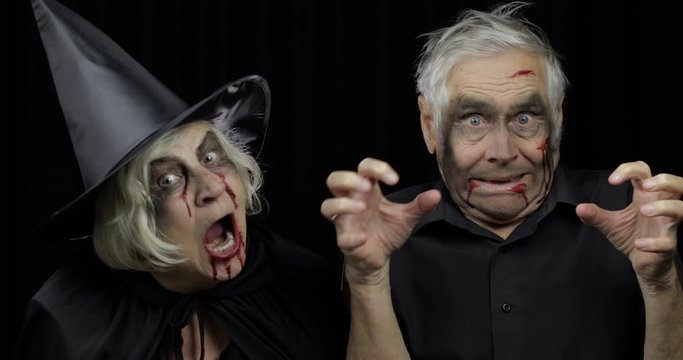 Elderly man and woman in Halloween costumes. Witch and zombie