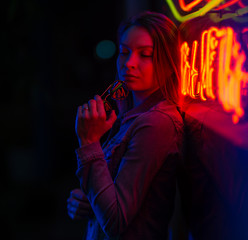 Sexy portrait of a young girl with an open bust in sunglasses and with in the night city, in the...