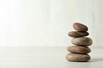 Stack of spa stones on table against white background, space for text