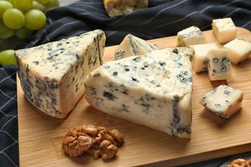 Board of delicious blue cheese with snacks on table