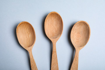 New wooden spoons on white background, top view