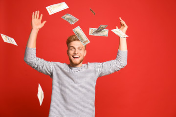 Portrait of happy lottery winner under money rain on red background
