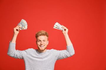 Portrait of happy lottery winner with money on red background