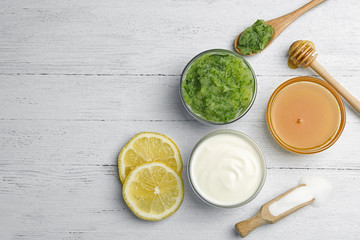 Handmade face mask made and different ingredients on white wooden table, flat lay. Space for text