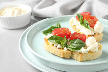 Tasty fresh tomato bruschettas on grey table