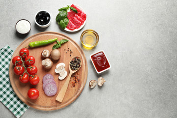 Flat lay composition with fresh pizza  ingredients on grey table. Space for text
