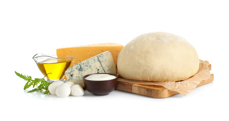 Fresh dough and ingredients for pizza on white background