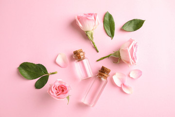 Flat lay composition with rose essential oil on pink background