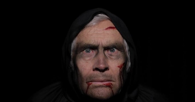 Old executioner Halloween makeup and costume. Elderly man with blood on his face