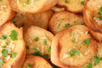 Slices of delicious toasted bread with garlic and herbs, closeup