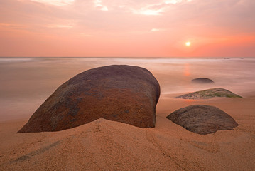 Long exposure sunrise by a beach in Tayrona National Park with boulder rocks, Cartagena, Colombia. 