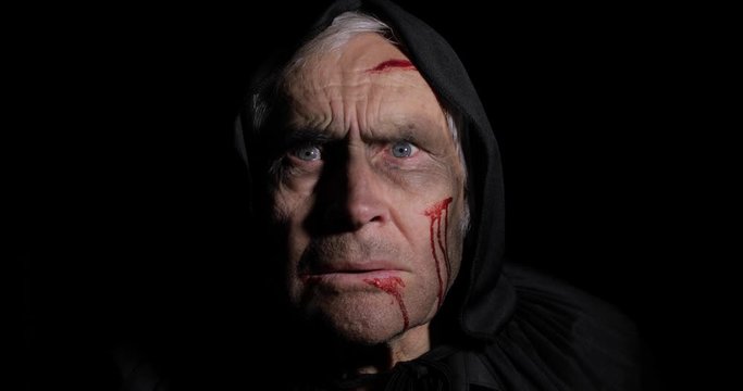 Old executioner Halloween makeup and costume. Elderly man with blood on his face