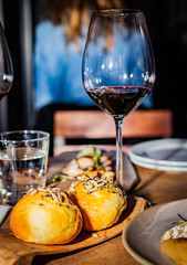 Grilled octopus and meat next to a glass of wine